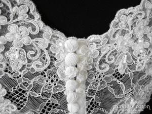 Bianco Evento - Boléro décolleté en V boutonné dans le dos à manches courtes en fine dentelle ivoire